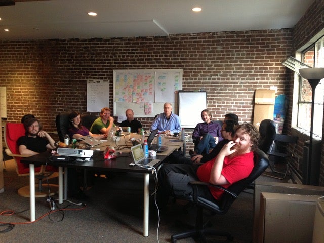 A small and mighty team of <10 gather for a meeting in an early Fastly office.