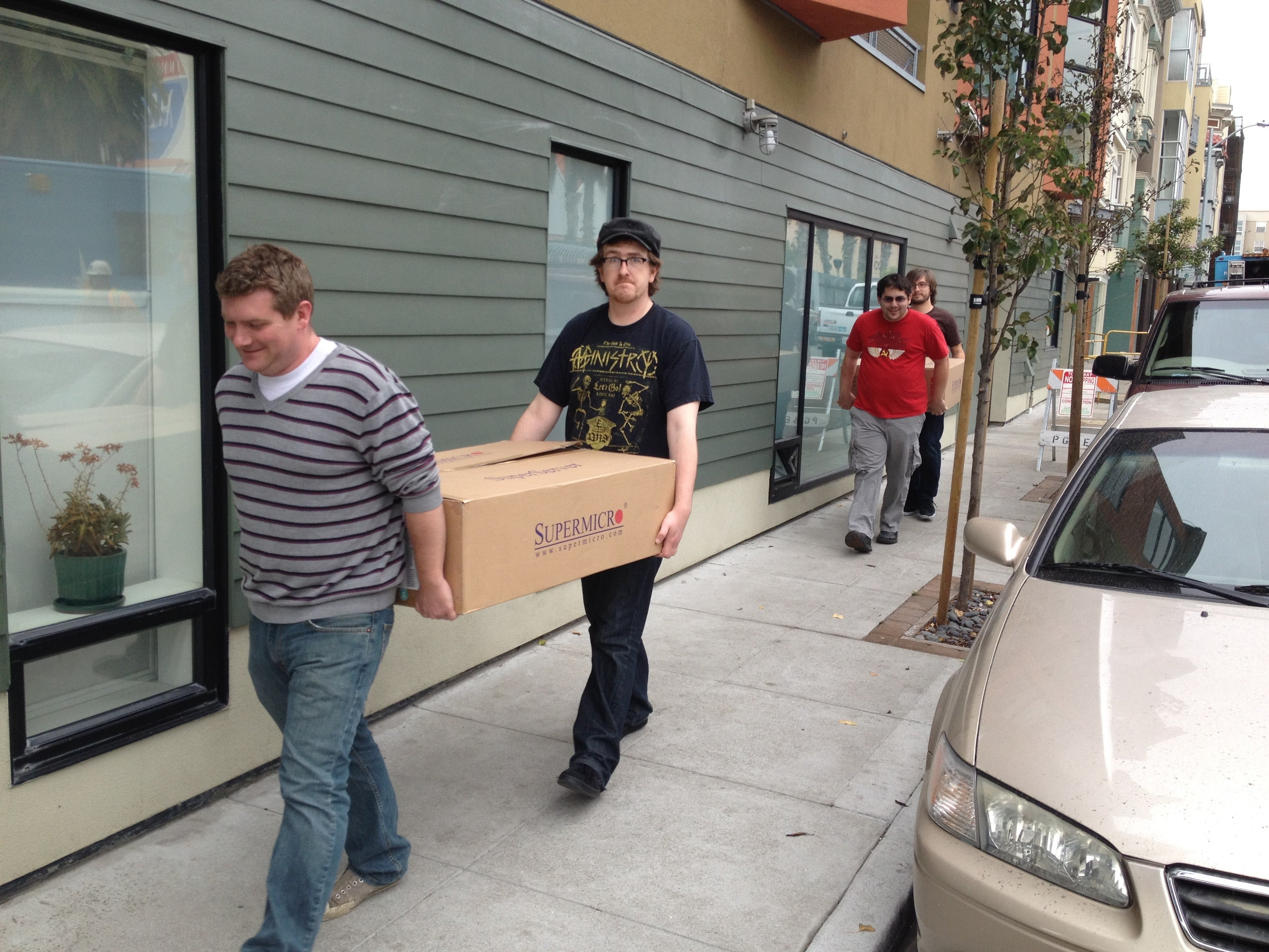 Simon Wistow and Patrick McManus carry a box across the street to Fastly’s new office. 