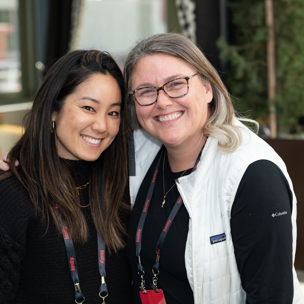 Dos empleados de Fastly sonriendo abrazados