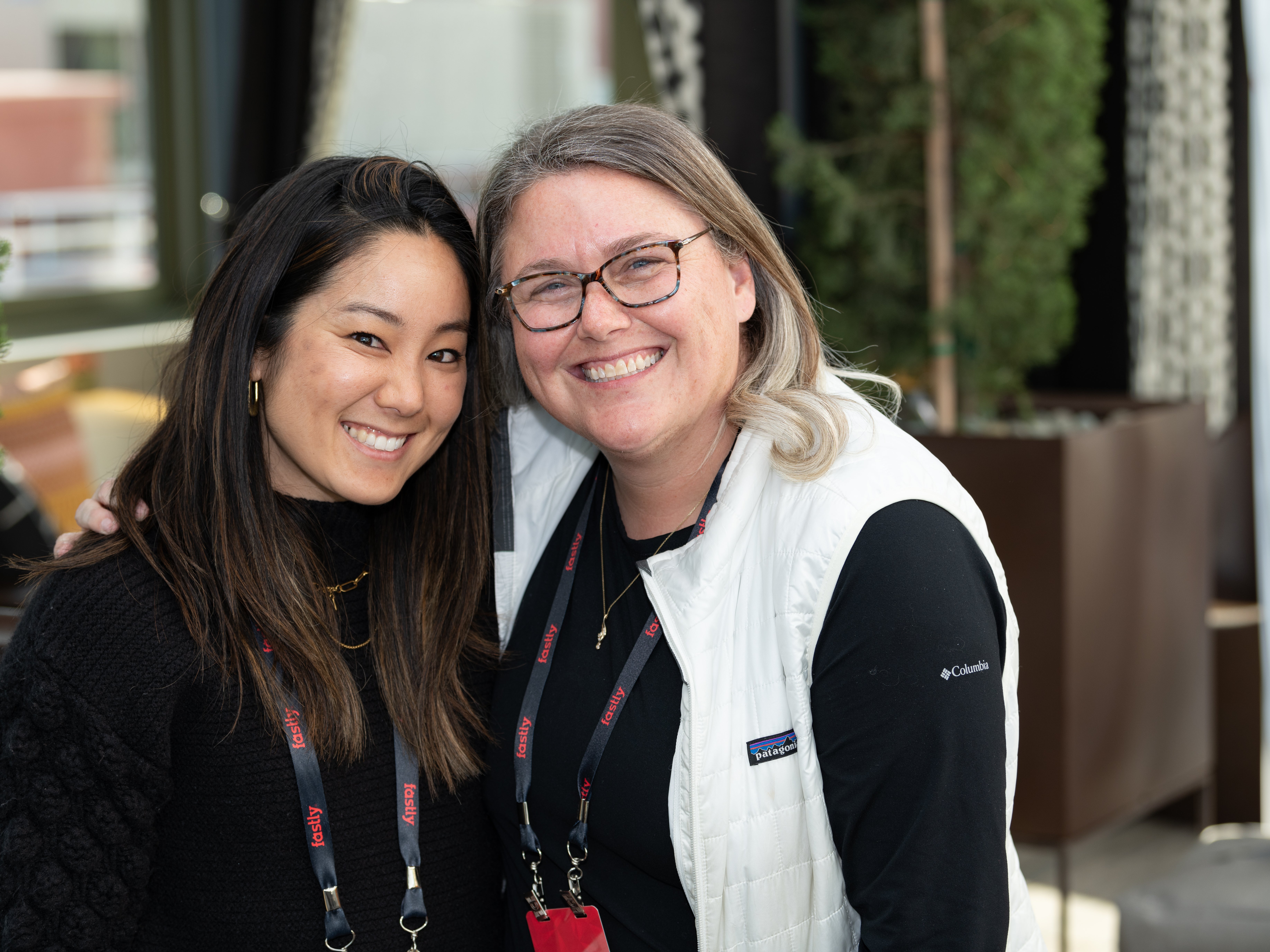 Dos empleados de Fastly sonriendo abrazados